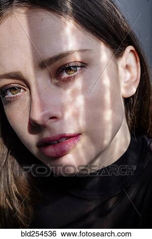 Stock Photograph - Shadow on face of serious Caucasian woman. Fotosearch