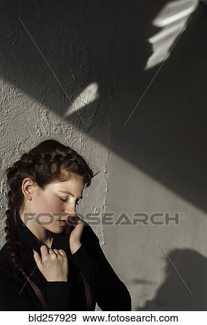 Shadow on wall over pensive Caucasian woman View Large Photo Image Stock Photo - Shadow on wall over pensive Caucasian woman. Fotosearch