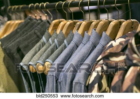 Shirts and pants hanging on clothing rack in retail store View Large Photo Image Stock Image - Shirts and pants hanging on clothing rack in retail store. Fotosearch