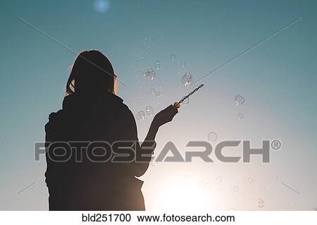 Silhouette of a woman waving bubble wand View Large Photo Image Stock Image - Silhouette of a woman waving bubble wand. Fotosearch