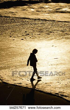 Silhouette of mixed race boy walking on beach at sunset View Large Photo Image Stock Image - Silhouette of mixed race boy walking on beach at sunset. Fotosearch