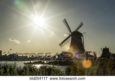 Silhouette of windmill at waterfront View Large Photo Image Stock Photo - Silhouette of windmill at waterfront. Fotosearch