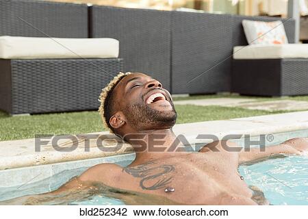 Smiling Black man relaxing in swimming pool View Large Photo Image Stock Image - Smiling Black man relaxing in swimming pool. Fotosearch