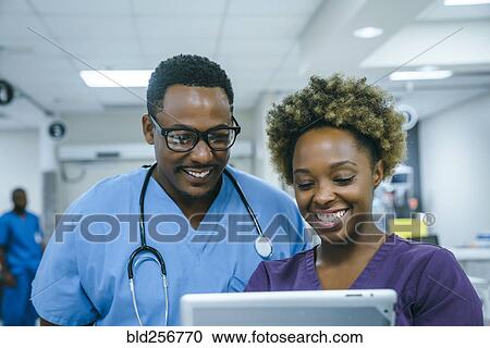 Smiling black nurses using digital tablet View Large Photo Image Stock Image - Smiling black nurses using digital tablet. Fotosearch
