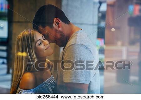 Picture - Smiling Caucasian couple behind window. Fotosearch