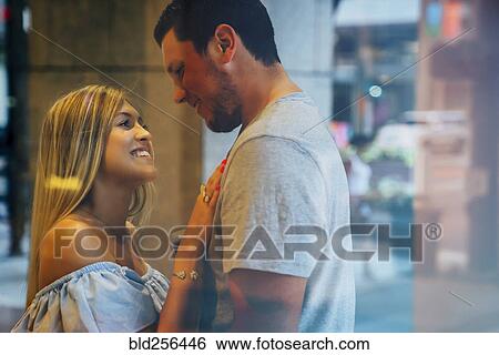 Stock Photograph - Smiling Caucasian couple behind window. Fotosearch