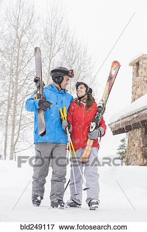 Smiling Caucasian couple carrying skis View Large Photo Image Stock Photo - Smiling Caucasian couple carrying skis. Fotosearch