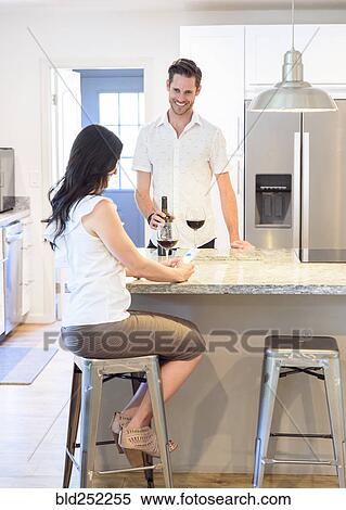 Smiling Caucasian couple drinking red wine in kitchen View Large Photo Image Stock Photography - Smiling Caucasian couple drinking red wine in kitchen. Fotosearch