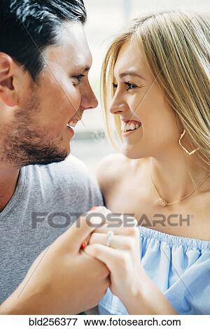 Stock Photo - Smiling Caucasian couple holding hands. Fotosearch
