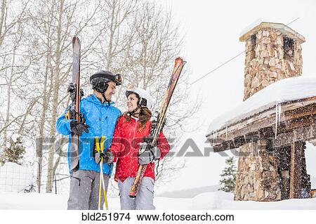 Smiling Caucasian couple holding skis at resort View Large Photo Image Picture - Smiling Caucasian couple holding skis at resort. Fotosearch