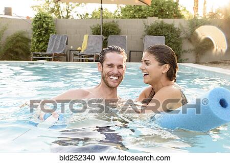 Smiling Caucasian couple relaxing in swimming pool View Large Photo Image Stock Image - Smiling Caucasian couple relaxing in swimming pool. Fotosearch