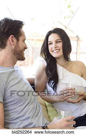 Smiling Caucasian couple relaxing with cold drinks View Large Photo Image Picture - Smiling Caucasian couple relaxing with cold drinks. Fotosearch