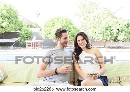 Smiling Caucasian couple relaxing with cold drinks outdoors View Large Photo Image Stock Photography - Smiling Caucasian couple relaxing with cold drinks outdoors. Fotosearch