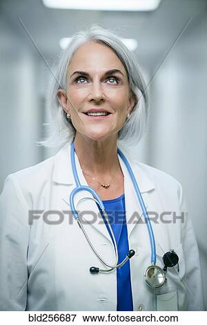 Stock Photo - Smiling Caucasian doctor looking up. Fotosearch