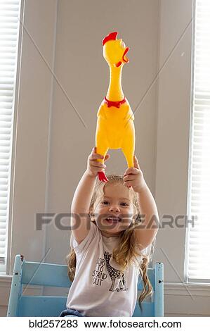 Smiling Caucasian girl holding rubber chicken View Large Photo Image Stock Image - Smiling Caucasian girl holding rubber chicken. Fotosearch