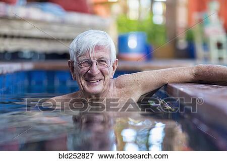 Stock Photo - Smiling Caucasian man in swimming pool. Fotosearch