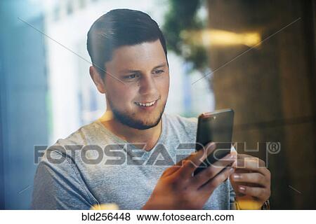 Smiling Caucasian man texting on cell phone View Large Photo Image Stock Photo - Smiling Caucasian man texting on cell phone. Fotosearch