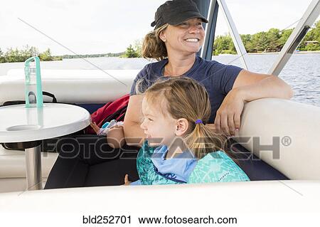 Smiling Caucasian mother and daughter relaxing on boat View Large Photo Image Stock Image - Smiling Caucasian mother and daughter relaxing on boat. Fotosearch