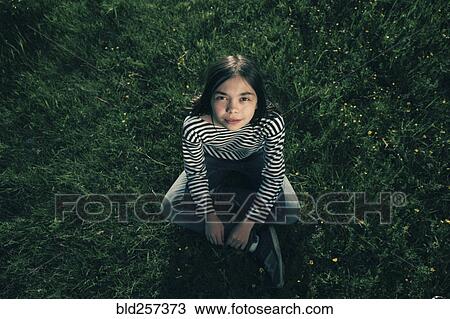 Smiling Caucasian teenage girl sitting in grass View Large Photo Image Stock Image - Smiling Caucasian teenage girl sitting in grass. Fotosearch