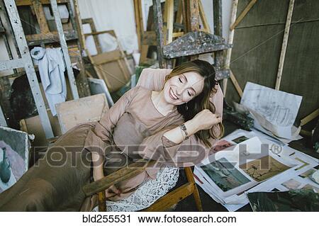 Smiling Caucasian woman laying in chair View Large Photo Image Stock Image - Smiling Caucasian woman laying in chair. Fotosearch