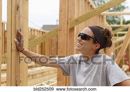 Smiling Caucasian woman leaning on frame a construction site View Large Photo Image Stock Photo - Smiling Caucasian woman leaning on frame a construction site. Fotosearch