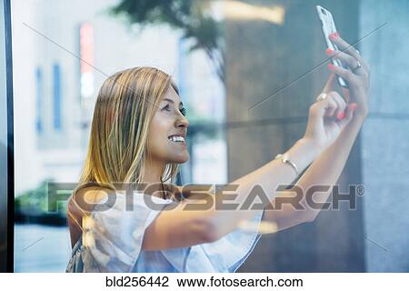 Smiling Caucasian woman posing for cell phone selfie View Large Photo Image Stock Image - Smiling Caucasian woman posing for cell phone selfie. Fotosearch
