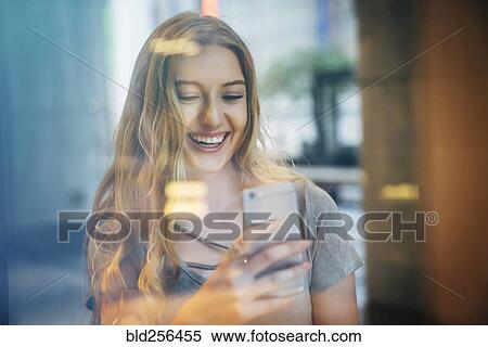 Smiling Caucasian woman posing for cell phone selfie behind window View Large Photo Image Stock Photography - Smiling Caucasian woman posing for cell phone selfie behind window. Fotosearch