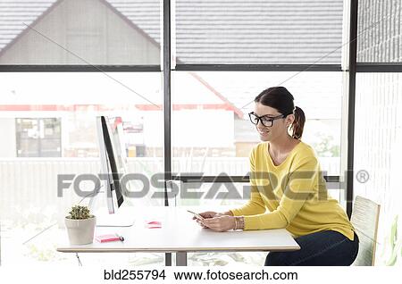 Smiling Caucasian woman texting on cell phone View Large Photo Image Picture - Smiling Caucasian woman texting on cell phone. Fotosearch