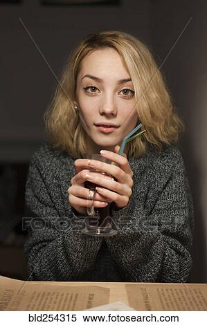 Stock Photography - Smiling Caucasian woman warming hands holding coffee. Fotosearch