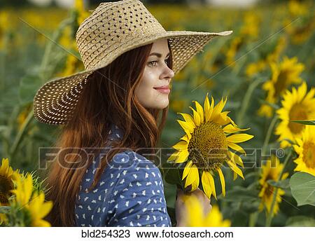 Smiling Caucasian woman wearing hat in field of sunflowers View Large Photo Image Stock Image - Smiling Caucasian woman wearing hat in field of sunflowers. Fotosearch