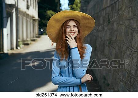 Smiling Caucasian woman wearing hat near stone wall View Large Photo Image Picture - Smiling Caucasian woman wearing hat near stone wall. Fotosearch
