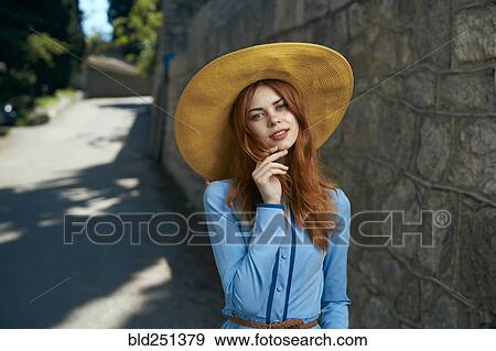 Smiling Caucasian woman wearing hat near stone wall View Large Photo Image Stock Photo - Smiling Caucasian woman wearing hat near stone wall. Fotosearch
