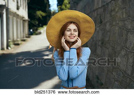 Smiling Caucasian woman wearing hat near stone wall View Large Photo Image Stock Photograph - Smiling Caucasian woman wearing hat near stone wall. Fotosearch