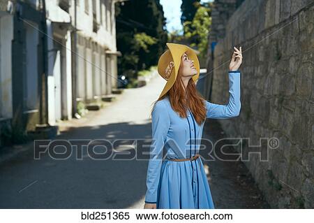 Smiling Caucasian woman wearing hat near stone wall View Large Photo Image Stock Photography - Smiling Caucasian woman wearing hat near stone wall. Fotosearch