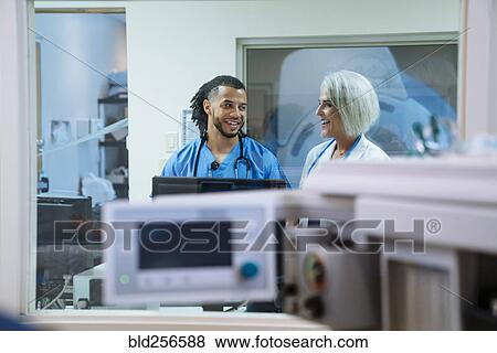 Stock Photo - Smiling doctor and nurse talking. Fotosearch