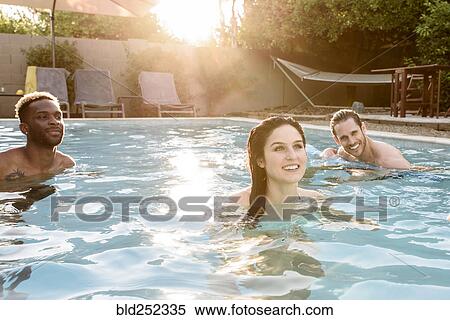 Smiling friends relaxing in swimming pool View Large Photo Image Stock Photography - Smiling friends relaxing in swimming pool. Fotosearch