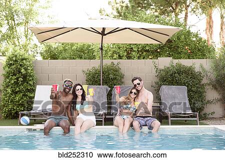 Smiling friends sitting and toasting poolside View Large Photo Image Stock Image - Smiling friends sitting and toasting poolside. Fotosearch