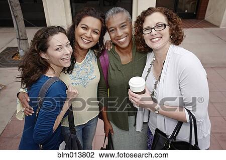 Smiling friends standing on sidewalk View Large Photo Image Stock Image - Smiling friends standing on sidewalk. Fotosearch