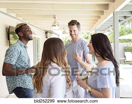 Smiling friends with cold drinks talking outdoors View Large Photo Image Stock Photo - Smiling friends with cold drinks talking outdoors. Fotosearch