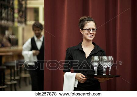 Smiling Hispanic waitress carrying tray of wine glasses View Large Photo Image Stock Photo - Smiling Hispanic waitress carrying tray of wine glasses. Fotosearch