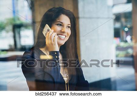 Smiling Hispanic woman talking on cell phone View Large Photo Image Stock Photo - Smiling Hispanic woman talking on cell phone. Fotosearch