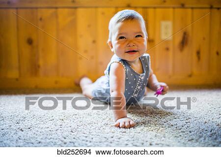 Smiling mixed race baby girl crawling on carpet View Large Photo Image Picture - Smiling mixed race baby girl crawling on carpet. Fotosearch