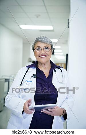 Smiling mixed race doctor holding digital tablet View Large Photo Image Stock Photo - Smiling mixed race doctor holding digital tablet. Fotosearch