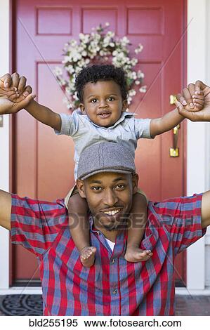 Smiling mixed race father carrying baby son on shoulders View Large Photo Image Stock Photography - Smiling mixed race father carrying baby son on shoulders. Fotosearch