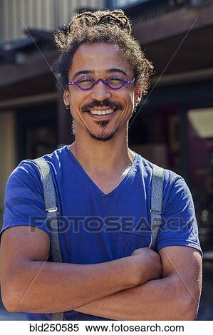 Stock Photography - Smiling mixed race man wearing suspenders. Fotosearch