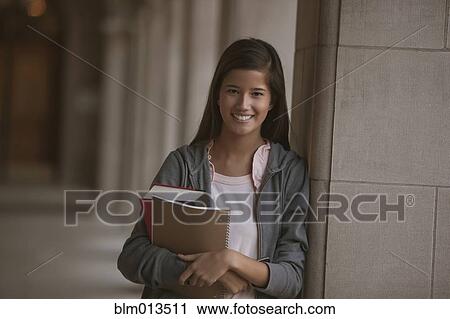 Stock Image - Smiling mixed race student on campus. Fotosearch