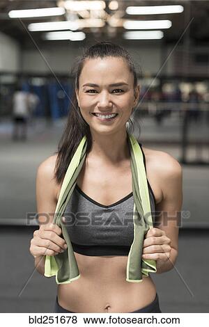 Smiling mixed race woman holding towel in gymnasium View Large Photo Image Stock Photo - Smiling mixed race woman holding towel in gymnasium. Fotosearch