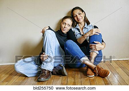 Smiling mixed race women sitting on floor View Large Photo Image Stock Image - Smiling mixed race women sitting on floor. Fotosearch