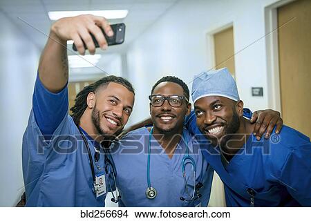 Smiling nurses posing for cell phone selfie View Large Photo Image Picture - Smiling nurses posing for cell phone selfie. Fotosearch