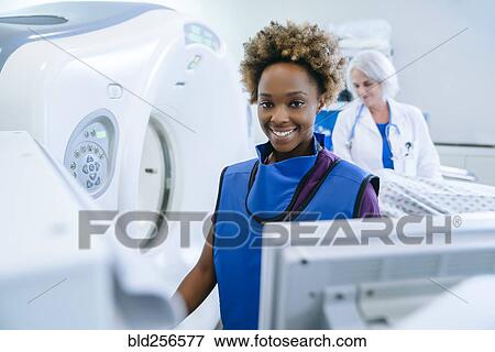 Smiling technician preparing scanner for doctor comforting patient View Large Photo Image Stock Photo - Smiling technician preparing scanner for doctor comforting patient. Fotosearch